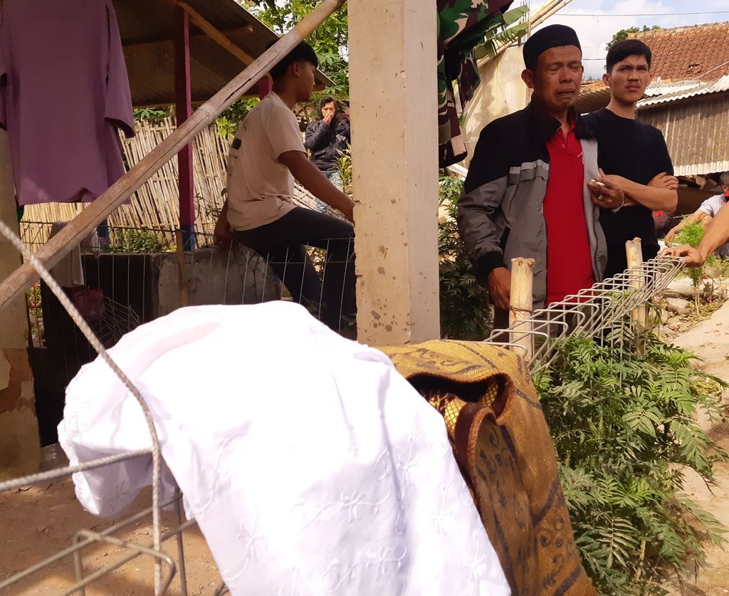 Asep Badar (45), warga Kampung Selaerih, Kabupaten Cianjur, Jawa Barat, menanti evakuasi putrinya oleh petugas SAR, TNI, dan sukarelawan, Selasa (22/11/2022).