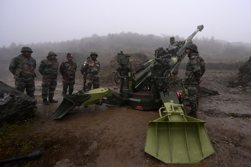 Tentara Angkatan Darat India berdiri di sebelah meriam Howitzer Ultra Ringan M777 yang ditempatkan di Penga Teng Tso di depan Tawang, dekat Garis Kontrol Aktual (LAC) yang berbatasan dengan China di negara bagian Arunachal Pradesh India, Rabu (20/10/2021). Dalam pernyataan pada Kamis (21/4/2022), Amerika Serikat memberikan 72 meriam sejenis ke Ukraina. 