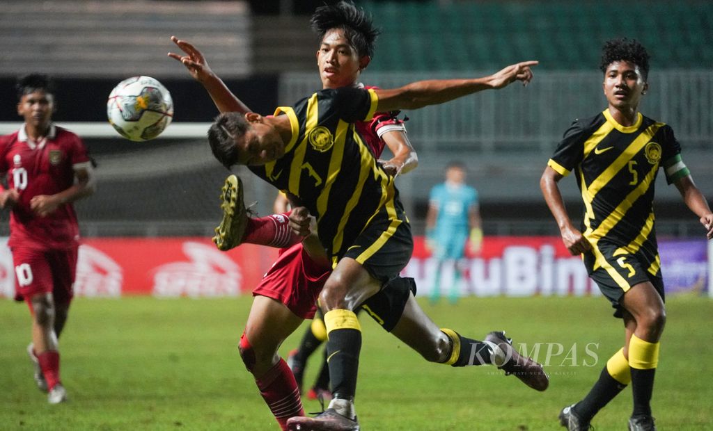 Indonesia U-17 midfielder Achmad Zidan Rosyid (back) fights for the ball with Malaysia U-17 team defender Muhammad Faris Danish (front) in the U-17 2023 Asian Cup Qualification match at Pakansari Stadium, Bogor, West Java, on Sunday (9/10/2022).