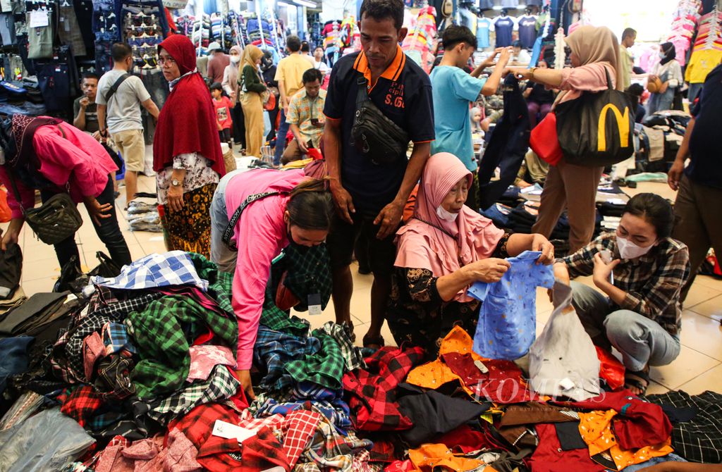 Pengunjung memilih pakaian yang dijual secara eceran di lapak pedagang di Pasar Cipulir, Kebayoran Lama, Jakarta Selatan, Rabu (12/4/2023). Pasar Cipulir menjadi salah satu pasar tekstil yang ramai dikunjungi jelang Lebaran selain Pasar Tanah Abang.