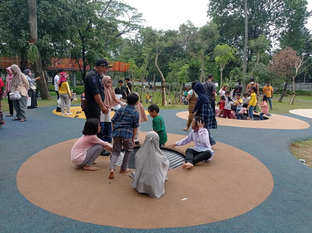 Petugas keamanan mengawasi anak-anak yang bermain trampolin di Tebet Eco Park, Jakarta Selatan, Kamis (5/5/2022). Arena permaian anak menjadi salah satu daya tarik taman ini.