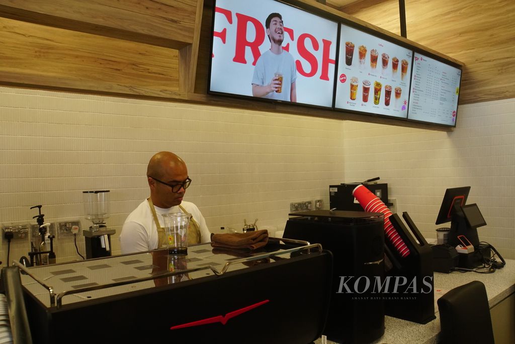 Seorang barista bekerja di konter Kenangan Coffee yang dibuka di kantor cabang Singapura, Senin (25/9/2023).