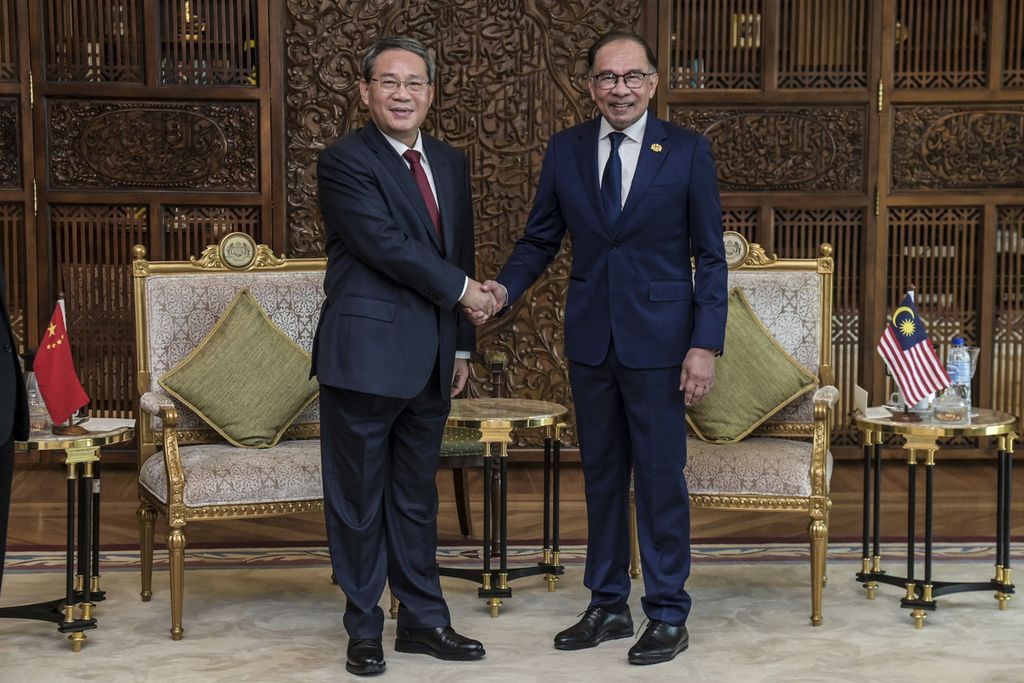 Perdana Menteri China berjabat tangan dengan Perdana Menteri Malaysia Anwar Ibrahim sebelum pertemuan di Putrajaya, Malaysia, Rabu (19/6/2024).