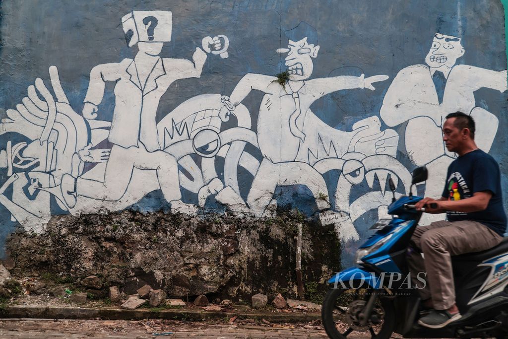 Warga melintas di depan mural bertema penegakan hukum di kawasan Buaran, Tangerang Selatan, Banten, Minggu (11/12/2022). Masa transisi tiga tahun sebelum penerapan Kitab Undang-undang Hukum Pidana (KUHP) baru akan dimanfaatkan pemerintah untuk sosialisasi masif kepada aparat penegak hukum.