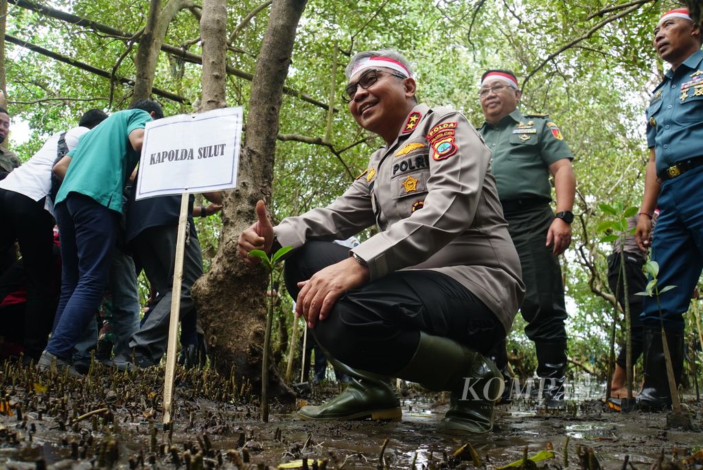 Kapolda Sulawesi Utara Inspektur Jenderal Setyo Budiyanto berpose bersama bibit mangrove yang ia tanam dalam acara penanaman 1.000 bibit pohon bakau atau mangrove di pantai yang terletak di bilangan Molas, Bunaken, Manado, Rabu (16/8/2023). Kegiatan itu adalah bagian dari penanaman 21 juta pohon secara serentak di seluruh Indonesia yang dimotori Polri, termasuk 16.850 pohon di Sulut.