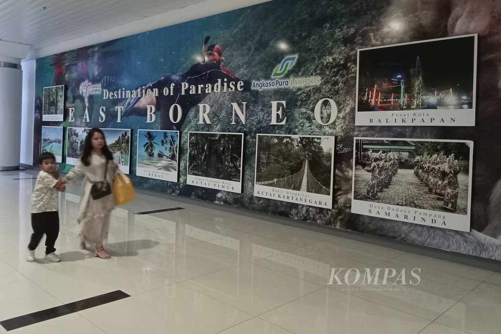 Penumpang melintas di depan iklan wisata di Bandara Internasional Sultan Aji Muhammad Sulaiman, Sepinggan, Balikpapan, Kalimantan Timur, Minggu (29/10/2023).