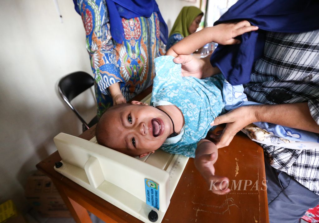 Anak balita menangis saat akan diukur tinggi badannya di Posyandu Bougenvile, Larangan Selatan, Kota Tangerang, Banten, Sabtu (11/1/2020). Pemeriksaan kesehatan, tumbuh kembang anak balita, serta pemberian imunisasi dilakukan secara berkala sebulan sekali. 