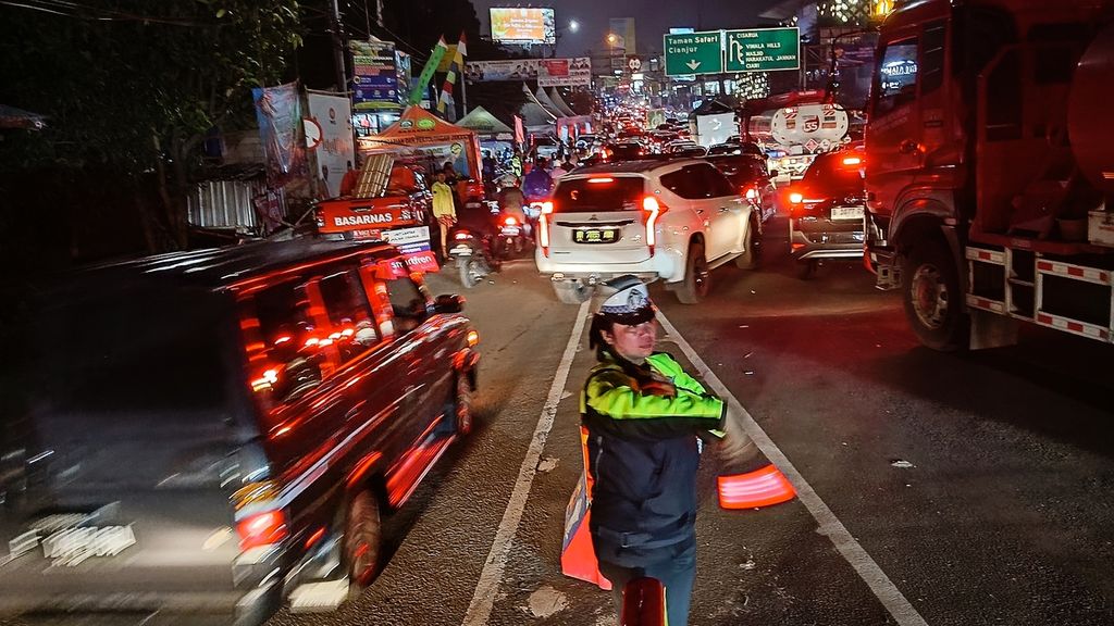Kondisi setelah sistem satu arah berakhir masih terjadi kepadatan dan antrean panjang kendaraan di Simpang Gadog. Seorang Polwan mengarahkan kendaraan yang akan menuju Puncak-Bogor, Sabtu (13/4/2024).