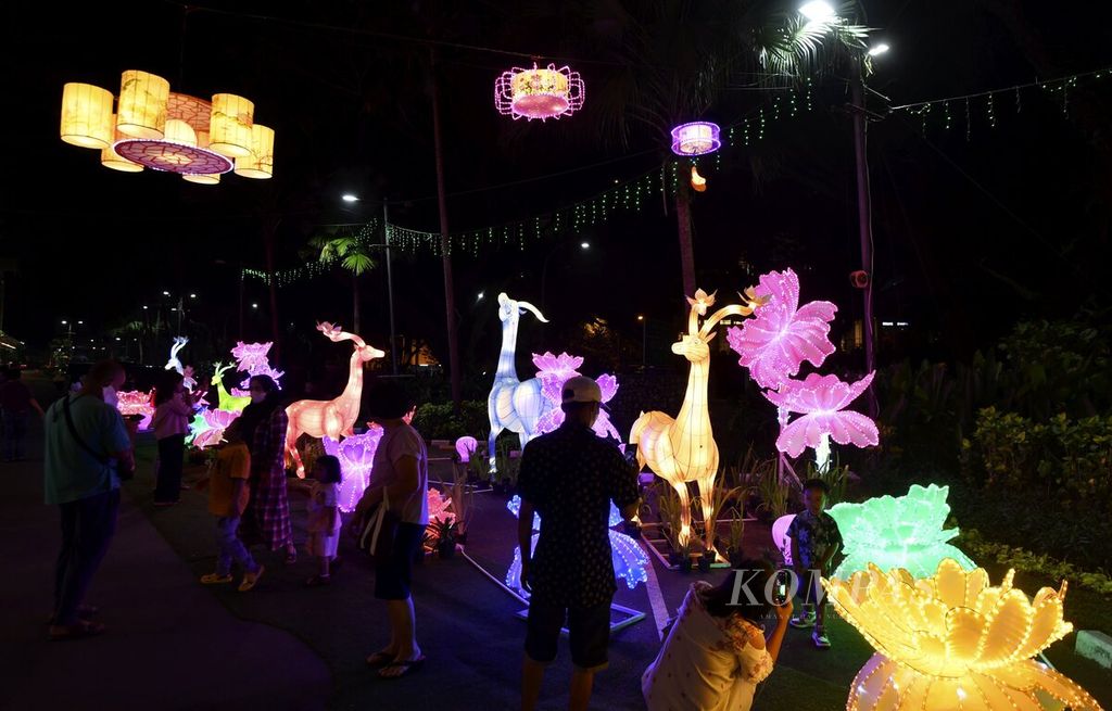 Pengunjumg menikmati kreasi lampion dengan beragam karakter saat pembukaan Festival Lentera di Mal Living Worid Alam Sutera, Tangerang Selatan, Selasa (17/1/2023) malam.\