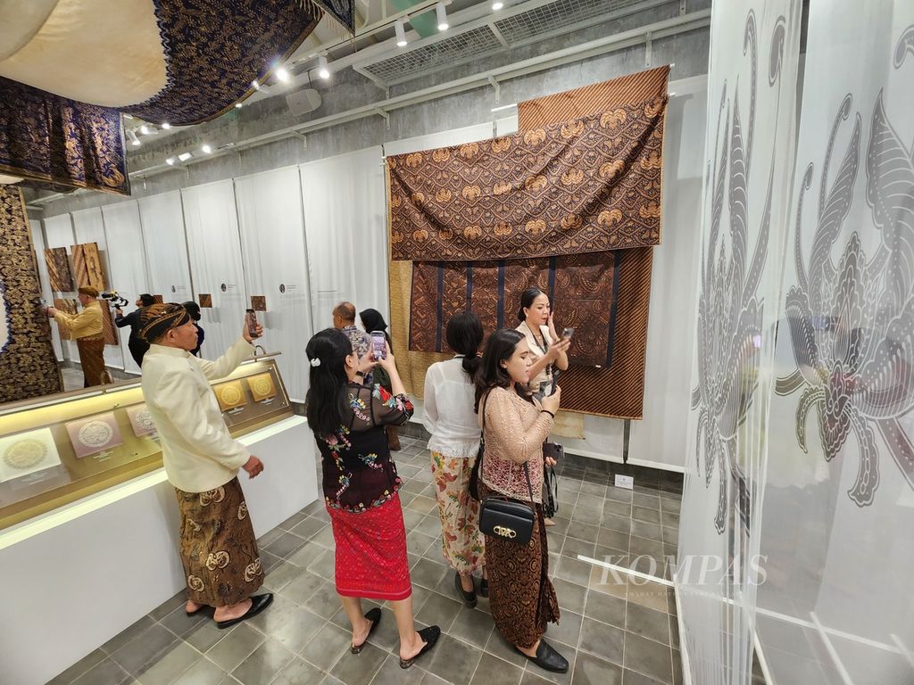 Pengunjung menyaksikan koleksi batik milik Pura Mangkunegaran dalam pergelaran "Angsukayana" di Pura Mangkunegaran, Kota Surakarta, Jawa Tengah, Minggu (29/10/2023). Misi pergelaran itu adalah mengenalkan kembali batik Mangkunegaran secara lebih luas. 
