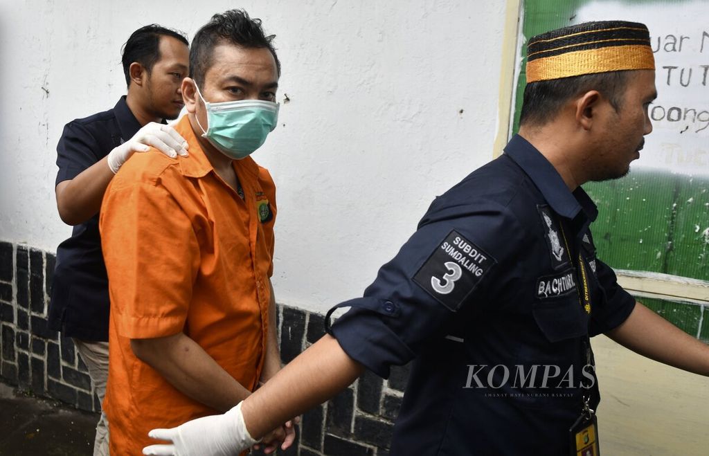 Polisi membawa tersangka MM alias dokter A pelaku praktik aborsi ilegal di rumah tinggal di Jalan Paseban Raya 61, Senen, Jakarta Pusat, Jumat (14/2/2020). 