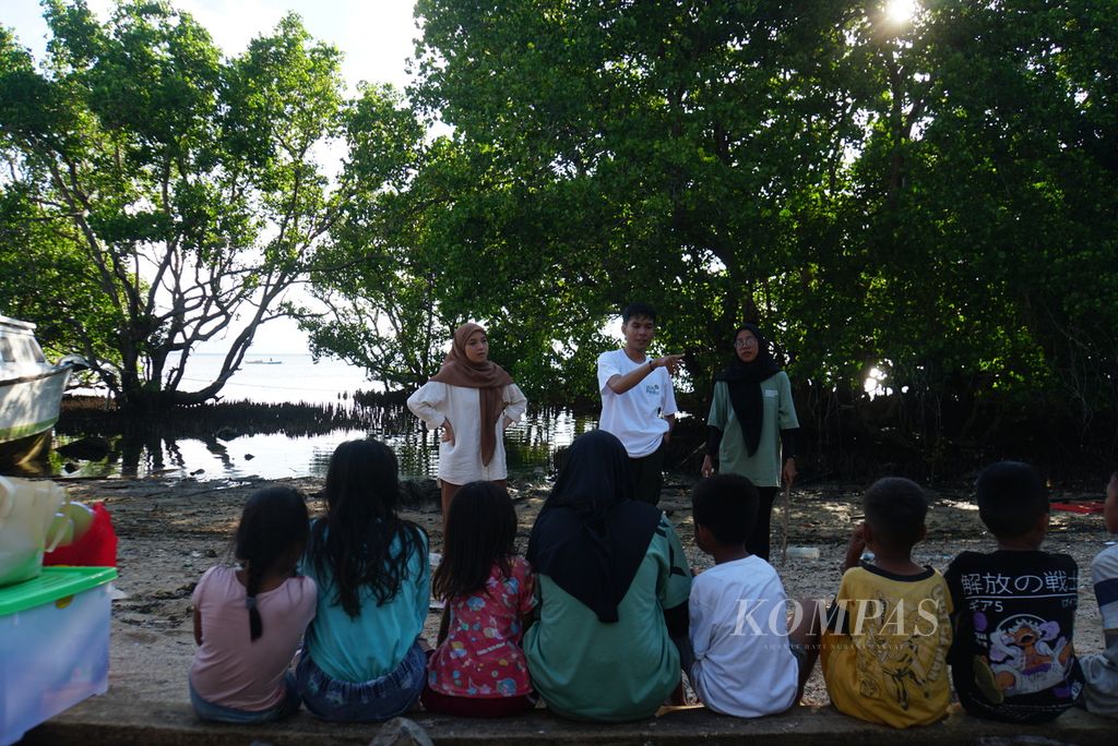 Farlan Erlangga (22, tengah) dan dua rekannya, Nurfadilah Thamrin (21, kiri) dan Saskia Kirana (20), memberikan arahan kepada anak-anak peserta kelas informal baca-tulis yang mereka selenggarakan, Sabtu (18/11/2023), di Pulau Bunaken, Manado, Sulawesi Utara. 