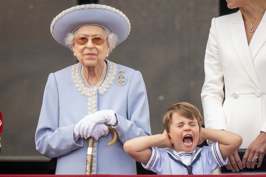 Ratu Elizabeth II berdiri saat Pangeran Louis menutup telinganya di balkon Istana Buckingham setelah upacara Trooping the Colour di Horse Guards Parade, London, Kamis (2/6/2022)