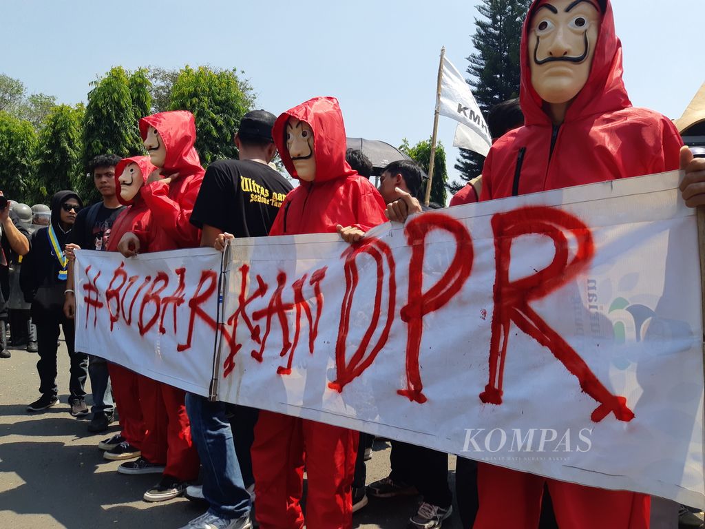 Para pengunjuk rasa mengenakan kostum yang terinspirasi serial <i>Money Heist</i> saat demonstrasi di depan kantor DPRD Lampung, Jumat (23/8/2024). 