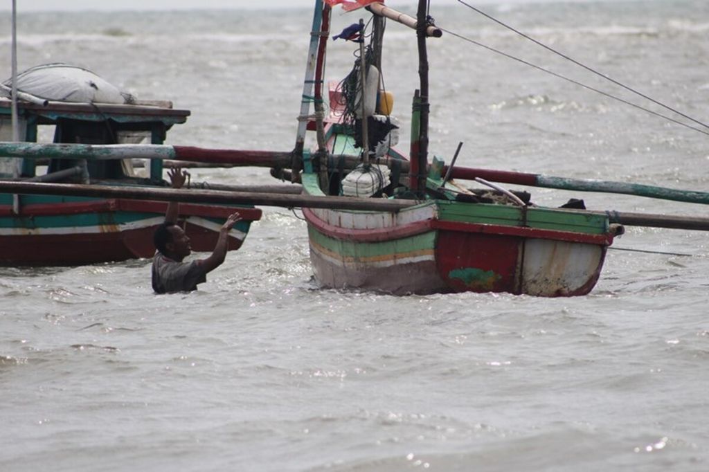 Seorang nelayan di Pantai Malabero, Bengkulu, tengah berusaha menggapai perahunya untuk mulai berlayar, Jumat (12/1). Sudah tiga bulan nelayan di perairan Bengkulu jarang melaut karena cuaca buruk.