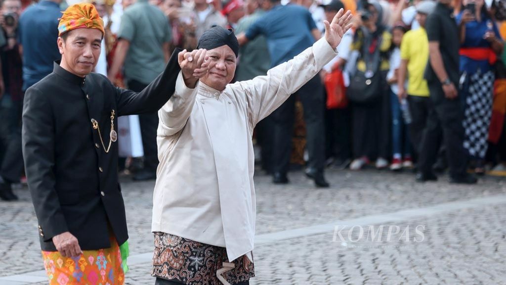 Capres nomor urut 01, Joko widodo (kiri) dan capres Nomor Urut 02, Prabowo Subianto, bergandengan tangan saat berjalan menuju tempat duduk usai Deklarasi Kampanye Damai Pemilu Serentak 2019 di Lapangan Monumen Nasional, Jakarta, Minggu (23/9/2018). 