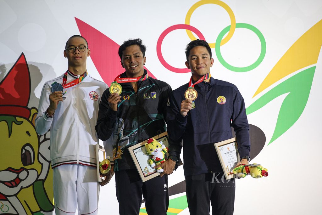 Perenang Sulawesi Tengah I Gede Siman (tengah), perenang DKI Jakarta Jason Donovan (kiri), dan perenang Papua Farrel Armando berfoto bersama setelah pengalungan medali cabang renang nomor 50 meter gaya punggung di PON Aceh-Sumut 2024 di Kolam Renang Selayang, Kota Medan, Sumatera Utara, Senin (16/9/2024). Siman meraih medali emas setelah mencatatkan waktu 25,46 detik. 