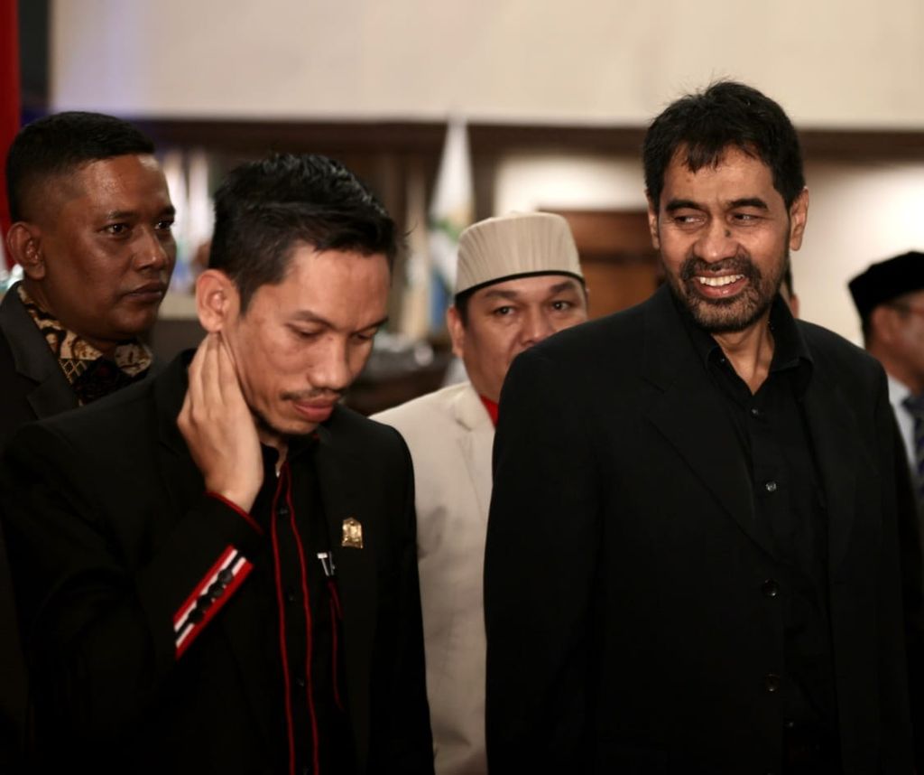 Muzakir Manaf (kanan) bersama anggota Dewan Perwakilan Rakyat Aceh, Tarmizi (kiri), sebelum pembukaan Musyawarah Besar III Partai Aceh, Minggu (26/2/2023). Muzakir Manaf kembali dipilih sebagai ketua umum.