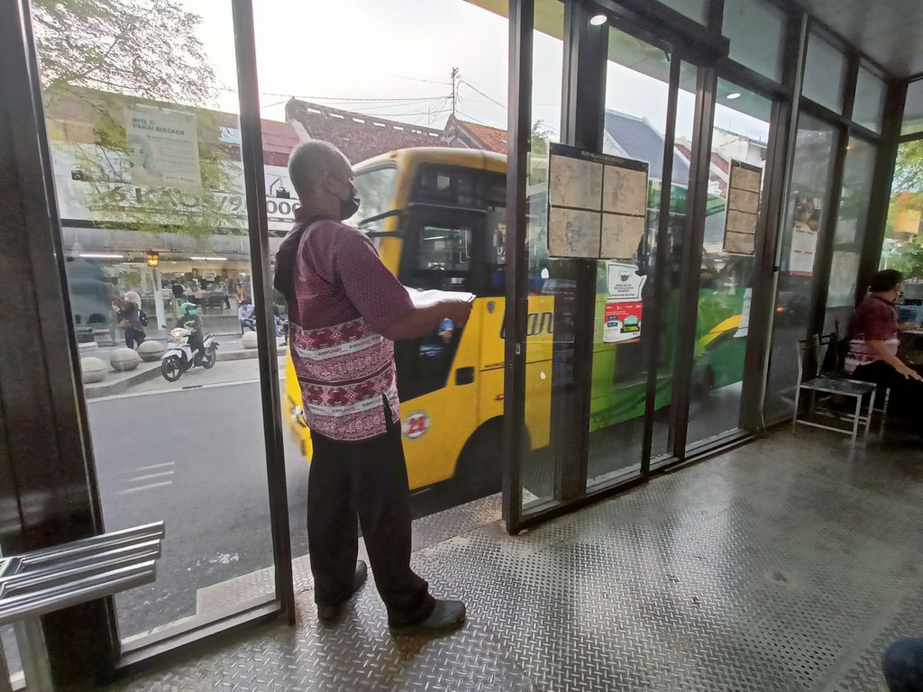 Seorang petugas sedang memberi aba-aba kepada sopir Bus Trans Jakarta ada tidaknya penumpang yang berangkat dari salah satu halte di Jalan Malioboro pada Jumat (4/3/2022).