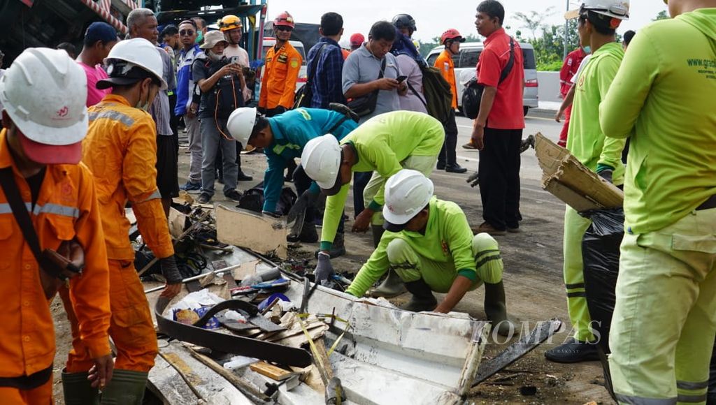 Petugas mengevakuasi puing-puing sisa kecelakaan tol yang melibatkan delapan unit kendaraan besar di Jalan Tol Semarang-Solo Km 487 A + 600, Kabupaten Boyolali, Jawa Tengah, Jumat (14/4/2023). Beberapa korban meninggal dan luka-luka akibat insiden tersebut. Polisi masih mendalami penyebab kecelakaan.