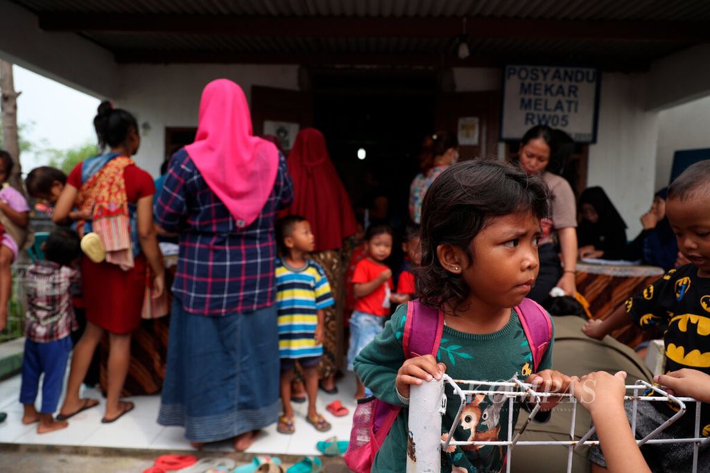 Anak-anak berserta orangtuanya mendatangi Posyandu Mekarsari untuk mengikuti imunisasi polio di Kampung Tambakrejo, Kota Semarang, Jawa Tengah, Senin (15/1/2024). 