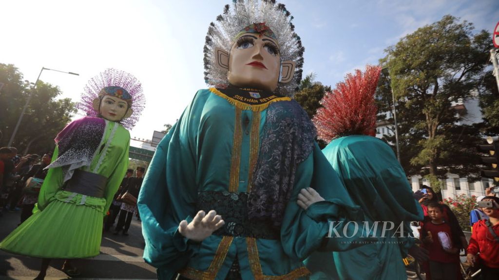 Arak-arakan ondel-ondel turut memeriahkan karnaval Lebaran Betawi melintasi Jalan Medan Merdeka Selatan, Jakarta Pusat menuju lapangan silang Monas saat berlangsung acara Lebaran Betawi, Minggu (21/7/2019)