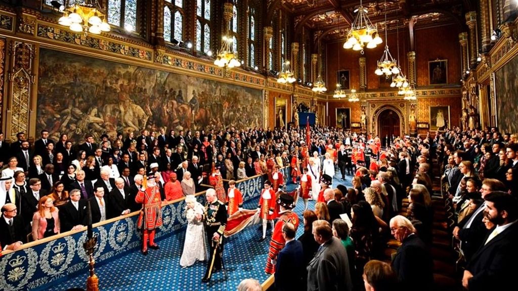 Ratu Inggris Elizabeth II didampingi putranya, Pangeran Charles, berjalan melalui jalur utama saat Pembukaan Sidang Parlemen Negara di Gedung Parlemen, London, Senin (14/10/2019). Acara itu adalah ruang bagi Ratu Elizabeth II melakukan tugas seremonialnya untuk memberi tahu parlemen—lewat Pidato Ratu—tentang agenda pemerintah tahun depan.