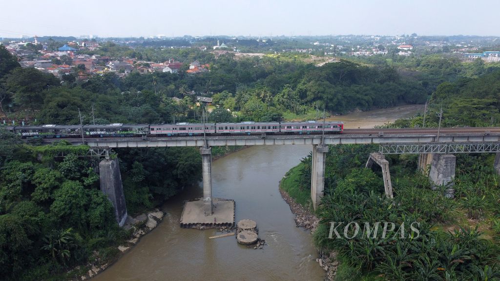 KRL Commuterline melintas di atas Sungai CIsadane di perbatasan Kecamatan Serpong, Tangerang Selatan dengan Kecamatan Cisauk, Kabupaten Tangerang, Banten, Selasa (16/5/2023). Mulai 1 Juni 2023, KAI Commuter akan memberlakukan perubahan dan penyesuaian pelayanan operasional perjalanan commuterline yaitu bertambah 61 perjalanan menjadi 1.232 perjalanan kereta komuter per hari di layanan Commuterline Jabodetabek, KA Lokal Merak, dan KA Bandara Soekarno-Hatta. 