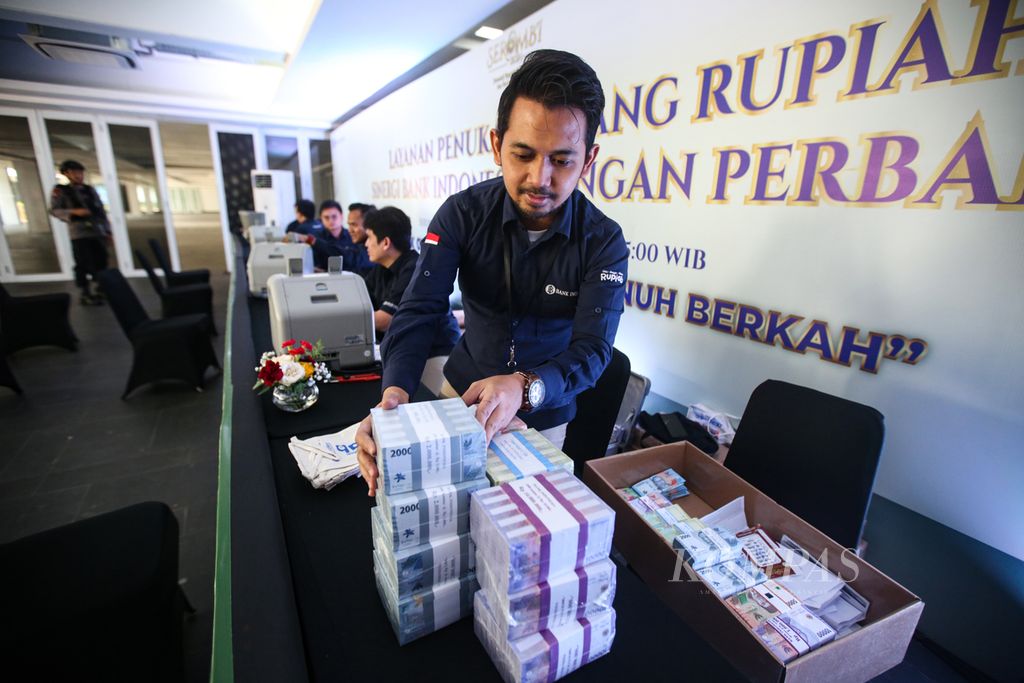 Petugas dari Bank Indonesia mempersiapkan uang baru berbagai pecahan di layanan kas keliling terpadu yang diselenggarakan oleh Bank Indonesia bersama perbankan di Istora Senayan, Jakarta, 28 Maret 2024. 