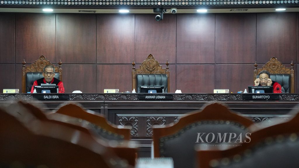 Ketua Mahkamah Konstitusi (MK) Anwar Usman keluar dari ruangan sidang saat hakim MK Saldi Isra (kiri) membacakan pendapat berbeda (<i>dissenting opinion</i>) atas putusan perkara uji materi syarat usia minimal calon presiden dan calon wakil presiden,  Senin (16/10/2023). 
