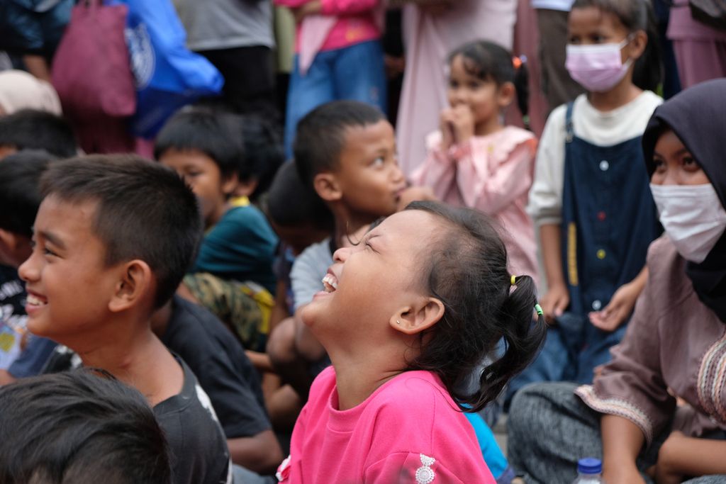 Seorang anak tertawa saat mendengarkan cerita anak di kawasan Kota Tua, Jakarta Barat, Sabtu (12/11/2022).  