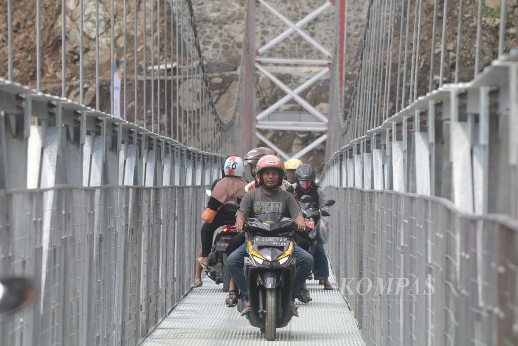 Masyarakat melintasi jembatan gantung Gladak Perak di Lumajang, Jawa Timur, Minggu (24/4/2022), . Jembatan yang sebelumnya putus akibat terdampak erupsi Semeru pada 4 Desember 2022 itu kini sudah siap dilintasi pemudik motor pada lebaran 2022.