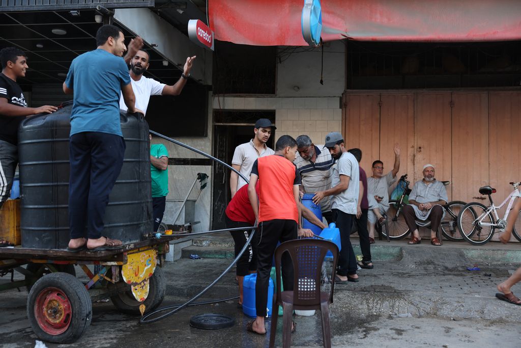 Warga mengisi galon air dari mobil tangki di Rafah di bagian selatan Jalur Gaza, Rabu (18/10/2023). Ribuan orang telah  berkumpul di sekitar pelintasan Rafah, perbatasan menuju ke Mesir untuk menunggu pembukaan guna penyaluran bantuan kemanusiaan.  