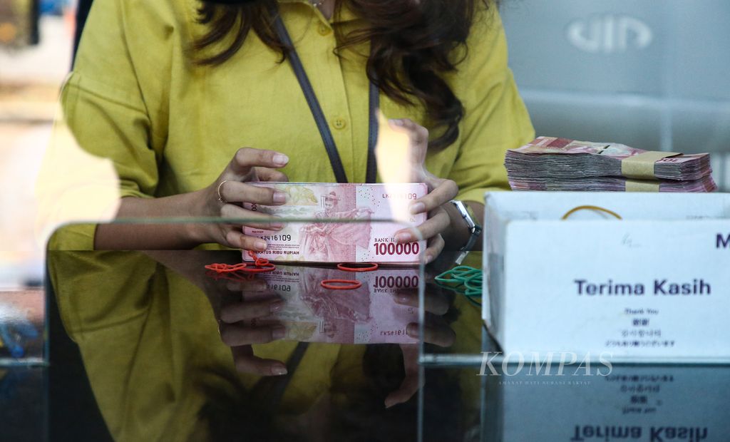 Petugas mempersiapkan uang rupiah di tempat penukaran valuta asing di Valuta Inti Prima di Cikini, Jakarta Pusat, Kamis (5/10/2023).