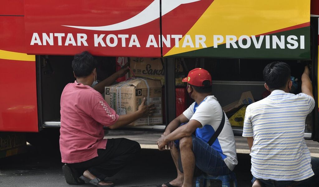 Awak bus menata barang para penumpang di dalam bagasi salah satu bus antarkota antar provinsi (AKAP) di Terminal Kalideres, Jakarta Barat, Minggu (2/5/2021).