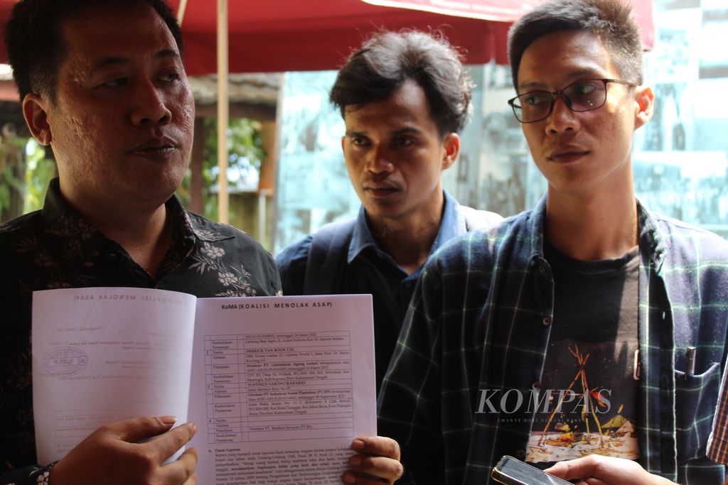 Direktur LBH Palangkaraya Aryo Nugroho memegang laporan mereka ke polisi terkait tindak pidana karhutla yang dilakukan oleh korporasi di Kalteng, Jumat (13/10/2023). Ia didampingi oleh Direktur Save Our Borneo (SOB) Muhammad Habibi (tengah) dan Direktur Eksekutif Walhi Kalteng Bayu Herinata (kanan).