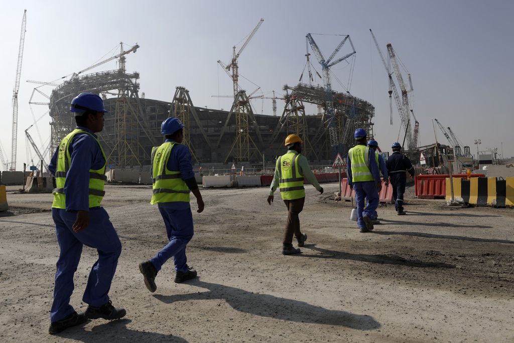 Para pekerja berjalan menuju Stadion Lusail, saat salah satu stadion Piala Dunia 2022 di Lusail, Qatar, itu masih dalam pembangunan, 20 Desember 2019. 