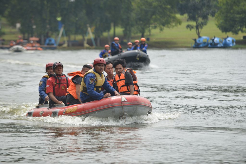 Sejumlah peserta acara apel kesiapsiagaan bencana melakukan simulasi evakuasi warga dari banjir di Buperta Cibubur, Cipayung, Jakarta Timur, Rabu (9/11/2022).