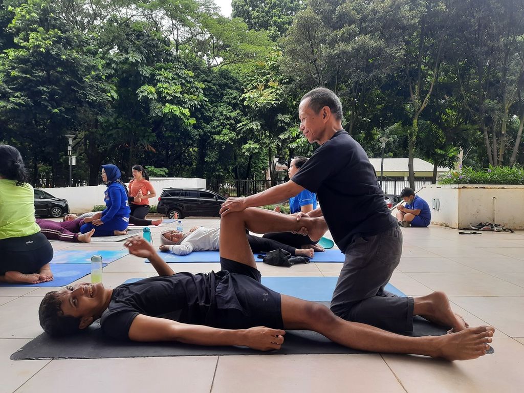 Anggota komunitas YogaDogether GBK, Iryanto Budi Utomo (64) sedang mengikuti kelas Zen Thai Massage di Stadion Akuatik, Gelora Bung Karno, Jakarta, Minggu (20/11/2022). Iryanto rutin melakukan yoga tiap hari selama 10-15 menit secara mandiri di rumah, sedangkan di akhir pekan ia selalu bergabung dalam kelas YogaDogether GBK.