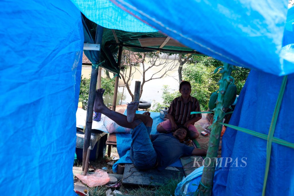 Beberapa hari ini, warga terpaksa tinggal di tenda pengungsian setelah banjir merendam rumah mereka di Kecamatan Karanganyar, Kabupaten Demak, Jawa Tengah, Senin (12/2/2024). 