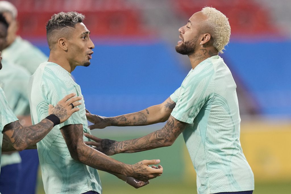 Penyerang Brasil, Neymar Jr (kanan), bersenda gurau dengan rekan setimnya, Raphinha pada sesi latihan di Stadion Grand Hamad di Doha, Qatar, Kamis (8/12/2022). Brasil akan menghadapi Kroasia pada laga perempat final Piala Dunia Qatar, Jumat (9/12/2022) malam WIB.