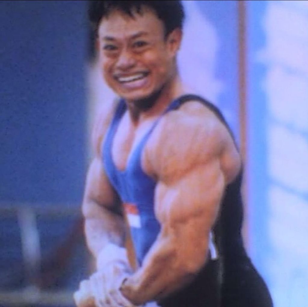 Erwin Abdullah memotret fotonya yang terpampang di <i>Kompas</i> edisi 5 Oktober 2002. Erwin berpose setelah mengetahui dirinya merebut medali perak Asian Games Busan, Korea Selatan, pada 2002. Erwin meraih perak dengan angkatan <i>clean and jerk</i> seberat 190 kg pada kelas 69 kg.