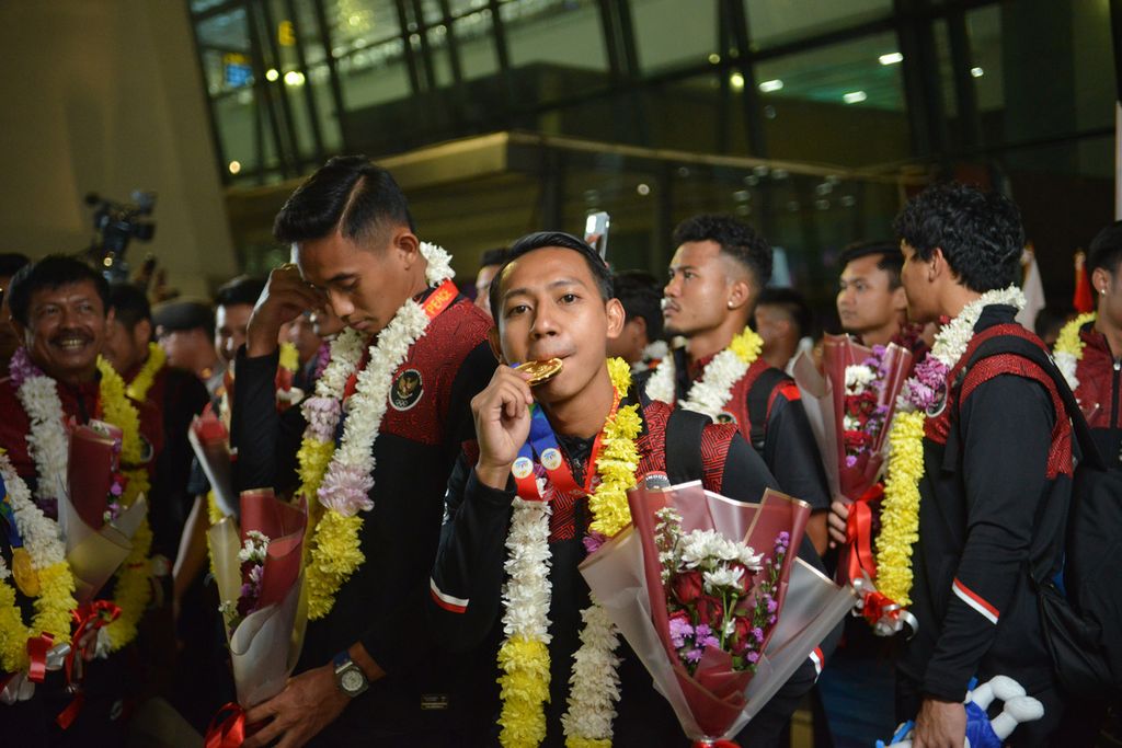 Pemain tim sepak bola Indonesia U-22, Beckham Putra, menggigit medali emas SEA Games 2023 di Bandara Internasional Soekarno-Hatta, Tangerang, Banten, Kamis (18/5/2023). Tim sepak bola Indonesia berhasil mendapatkan medali emas SEA Games 2023 setelah menanti selama 32 tahun. 