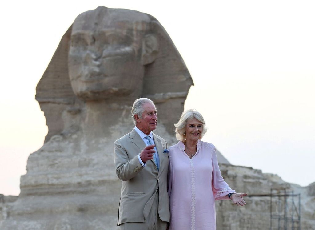 Foto yang diambil pada 19 November 2021 ini memperlihatkan Pangerang Inggris Charles (kiri) dan Camilla (C), Duchess of Cornwall, berfoto bersama di depan Patung Sphinx di Piramida Giza di pinggiran barat Kairo, Mesir.