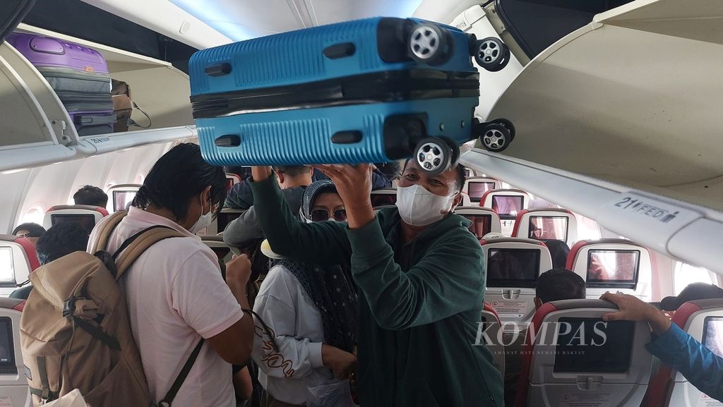 Penumpang mengeluarkan bagasi di kabin pesawat saat tiba di Bandara Internasional Soekarno-Hatta, Tangerang, Banten, Selasa (28/11/2023). Pascapandemi Covid-19 industri penerbangan domestik berangsur pulih dengan bertambahnya frekuensi penerbangan dan pembukaan rute baru.