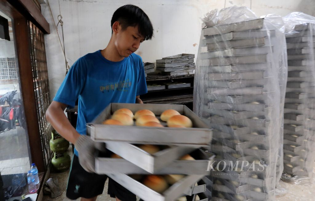 Pekerja mengeluarkan roti dari panggangan di pabrik skala rumahan di kawasan Kebon Nanas, Jakarta Selatan, Senin (16/1/2023). 