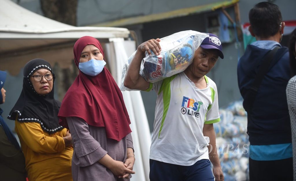 Buruh angkut membawa komoditas yang dibeli oleh warga saat Operasi Pasar Lumbung Pangan Jawa Timur di Pasar Pucang Anom, Kota Surabaya, Jawa Timur, Minggu (4/12/2022). 