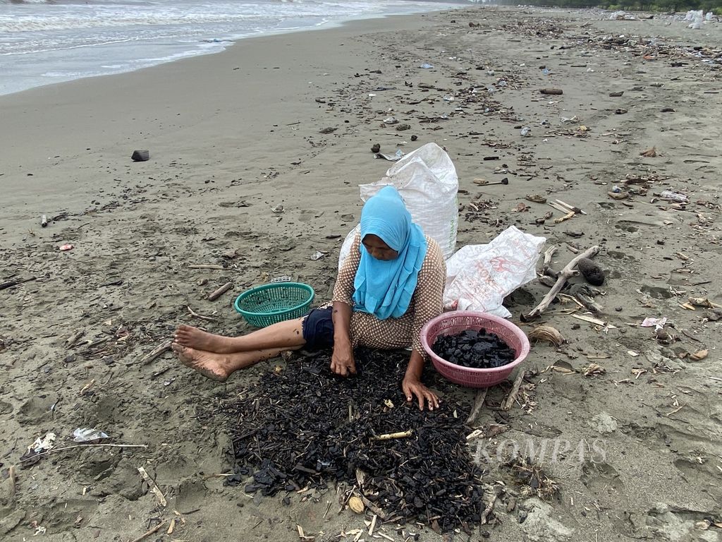 Warga mengumpulkan batubara di Pantai Peunaga Rayeuk, Kecamatan Meureuboe, Kabupaten Aceh Barat, Aceh, Minggu (15/10/2023). Batubara tersebut diduga tumpah dari kapal tongkang milik perusahaan.