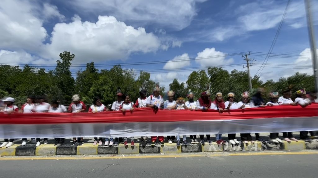 Suasana kemeriahan pengibaran bendera Merah Putih sepanjang 10 kilometer pada peringatan integrasi Papua ke NKRI di Kota Jayapura, Papua, Rabu (1/5/2024).