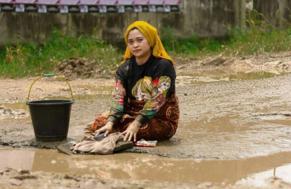 Ummu Hani (31), warga Desa Jatibaru, Kecamatan Tanjung Bintang, Kabupaten Lampung Selatan, memilih cara kreatif untuk menggambarkan kondisi jalan rusak di sekitar tempat tinggalnya.